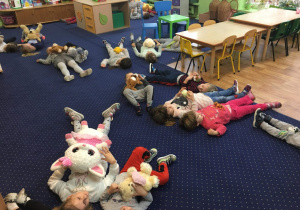 Dzieci leżą na dywanie.