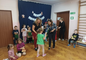 na saki gimnastycznej nauczycielki wręczają dzieciom nagrody za udział w konkursie plastycznym "Sensoryczny Miś"