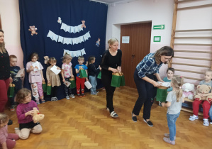 na saki gimnastycznej nauczycielki wręczają dzieciom nagrody za udział w konkursie plastycznym "Sensoryczny Miś"