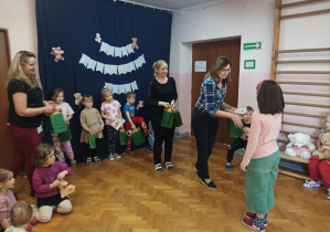 na saki gimnastycznej nauczycielki wręczają dzieciom nagrody za udział w konkursie plastycznym "Sensoryczny Miś"