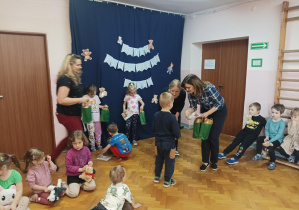 na saki gimnastycznej nauczycielki wręczają dzieciom nagrody za udział w konkursie plastycznym "Sensoryczny Miś"