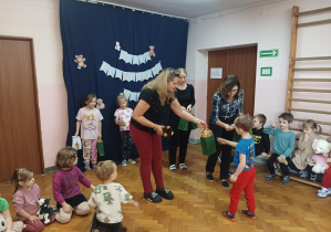 na saki gimnastycznej nauczycielki wręczają dzieciom nagrody za udział w konkursie plastycznym "Sensoryczny Miś"