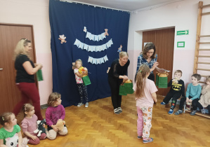 na saki gimnastycznej nauczycielki wręczają dzieciom nagrody za udział w konkursie plastycznym "Sensoryczny Miś"