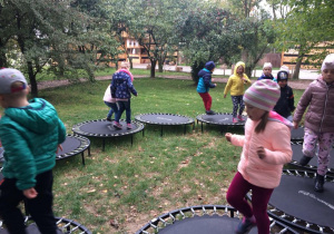 Dzieci z grupy 3 skaczą na tramploinach.