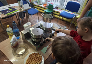 dzieci pieką gofry w gofrownicy