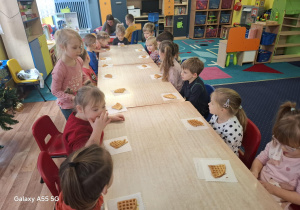 dzieci siedzą przy stolikach, zjadają upieczone gofry