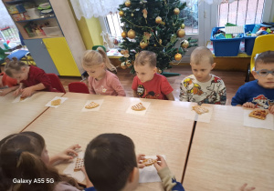 dzieci siedzą przy stolikach, zjadają upieczone gofry