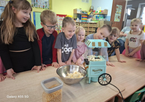 dzieci robią popcorn w specjalnej maszynie do popcornu