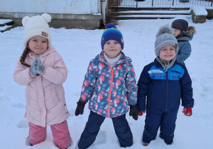 Dzieci pozują do zdjęcia w przedszkolnym ogrodzie.