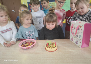 dziewczynka świętuje urodziny, dzieci składają hej życzenia