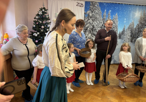 Dzieci z dziadkami prezentują przedmioty wykorzystywane przy zbieraniu ziół.