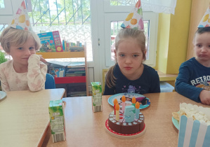 dziewczynka dmucha świeczkę na torcie