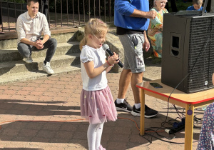 Dziewczynka śpiewa dla wszystkich gości.