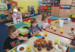 dzieci przy stolikach świętują urodziny koleżanki
