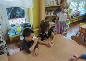 dzieci piją koktajl owocowy