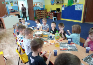 Dzieci siedzą przy stole.