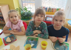 dzieci przy stolikach świętują dzień dziewczynki, na stolikach słodki poczęstunek