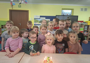 dziewczynka świetuje urodziny, dzieci składają jej życzenia