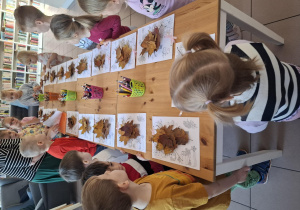 Dzieci stoją wokół stołu.