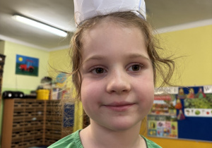 Dziewczynka prezentuje swoją koronę z origami.