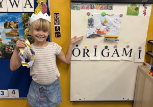 Dziewczynka prezentuje prace wykonane techniką origami.