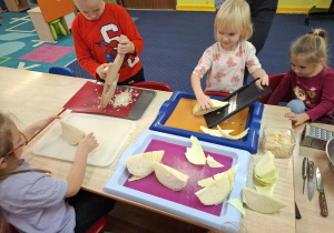 Dzieci szatkują kapustę.