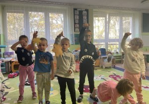 Dzieci tańczą z liśćmi do muzyki.