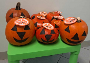 Ozdobione dynie leżą na stoliku.