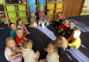 Dzieci siedzą w kole.