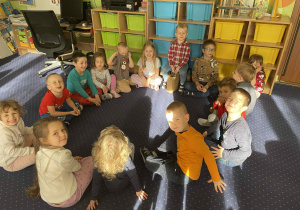 Dzieci siedzą w kole.