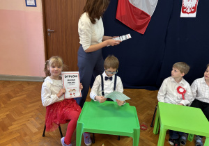 Dzieci otrzymują dyplomy.