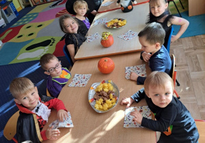 Dzieci siedzą przy stole.