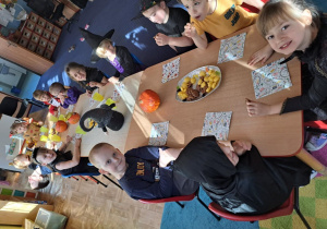 Dzieci siedzą przy stole.