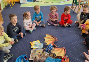 Dzieci siedzą w kole.