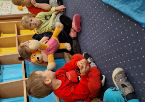 Dzieci siedzą w kole.