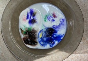 Talerz z wodą i zabarwione plamy.