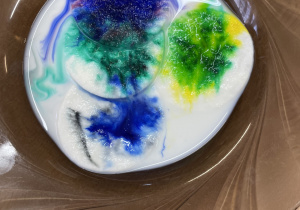 Talerz z wodą i zabarwione plamy.
