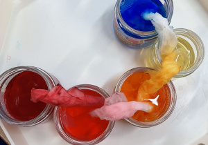 Słoiki z zabarwioną wodą.