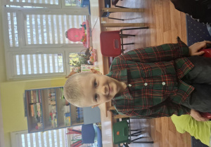 Chłopiec siedzi na krześle.