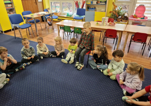 Dzieci siedzą w kole.