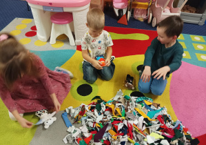 dzieci ozdabiają pluszowego misia podczas warsztatów