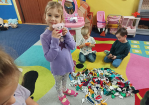 dzieci ozdabiają pluszowego misia podczas warsztatów