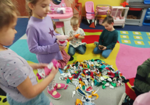 dzieci ozdabiają pluszowego misia podczas warsztatów