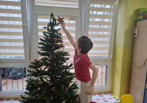 dzieci z 1 grupy ubierają choinkę w sali