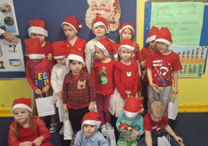 zdjęcie dzieci z grupy 1, dzieci ubrane na czerwono, w czapkach Mikołaja
