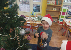 chłopiec wiesza bombkę na choince