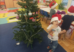 dziewczęta i chłopcy ubierają choinkę