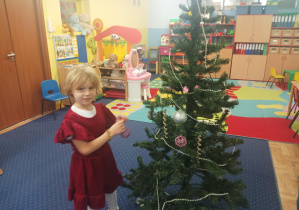 dziewczęta i chłopcy ubierają choinkę