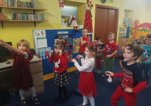 dzieci tańczą do muzyki przed tablicą interaktywną