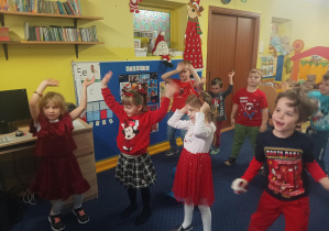 dzieci tańczą do muzyki przed tablicą interaktywną